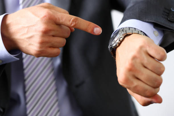 istock Man in suit and tie check out time at silver wristwatch 841167656
