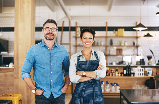 Portrait of a confident man and woman working together in a coffee shop