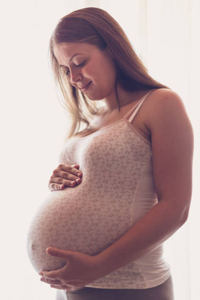 istock Beautiful Pregnant Woman Standing By Window 841184836
