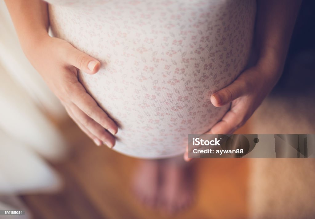 Pregnant woman touching her belly Pregnant woman holding baby bump Pregnant Stock Photo
