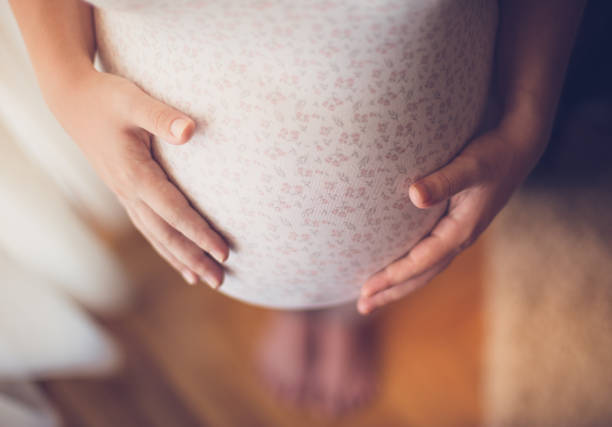 беременная женщина, касаясь ее живота - ухабистый стоковые фото и изображения