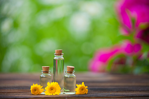 Essential Oil On Table In Beautiful Bottle With Flowers Stock Photo -  Download Image Now - iStock
