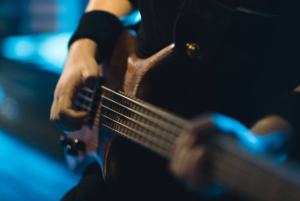 istock Man bass guitarist playing electrical guitar on concert stage 841189092