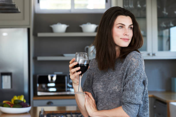 brunette genieten van wijn - drinking wine stockfoto's en -beelden