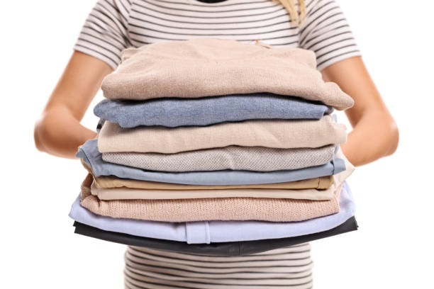 istock Woman holding a stack of ironed and packed clothes 841196170