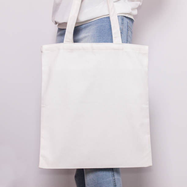 fille en jeans tient sac cabas en coton blanc eco, conception de maquette. sac à provisions à la main pour les filles - tote bag photos et images de collection