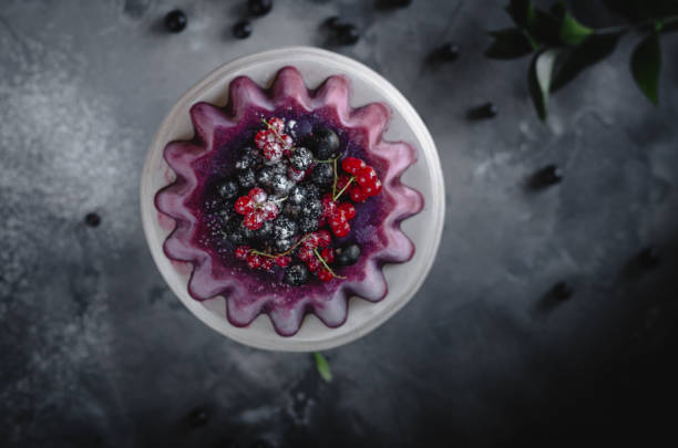 berry sorbet kuchen garniert mit frischen johannisbeeren und puderzucker mit weißen blumen, reben kranz auf grauem hintergrund - berry vine stock-fotos und bilder