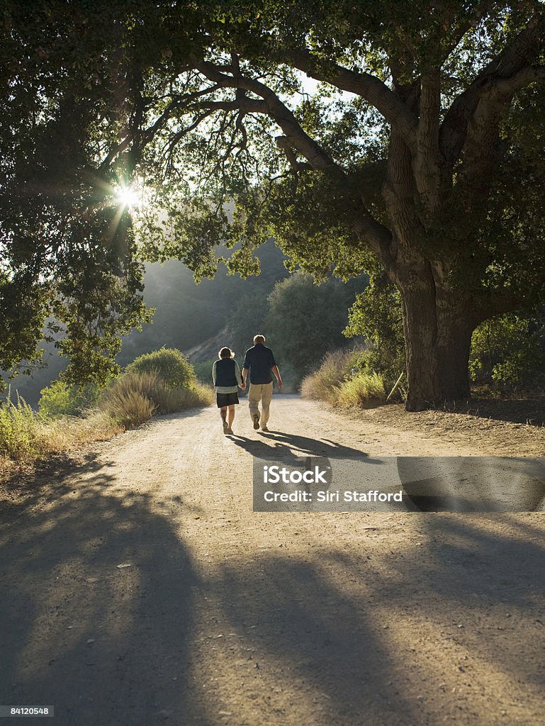 Casal caminhando pela dirt road - Foto de stock de Terceira idade royalty-free