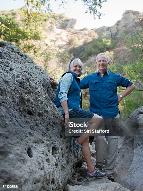 Mature Couple Leaning On Large Boulders Stock Photo - Download Image Now - California, Hiking, Senior Adult