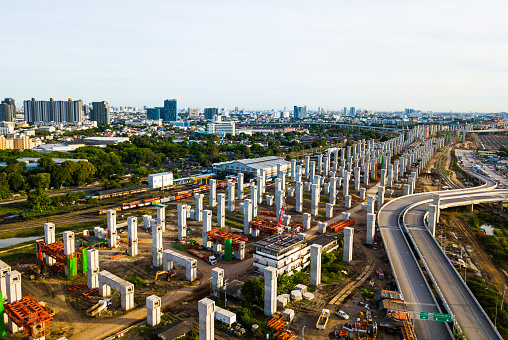 The infrastructure of sky train railway in the middle of Bangkok city. The pillars of foundation are posted in pattern line, coming out from the new main station.