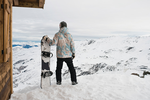 Snowboarder enjoying the mountain view.