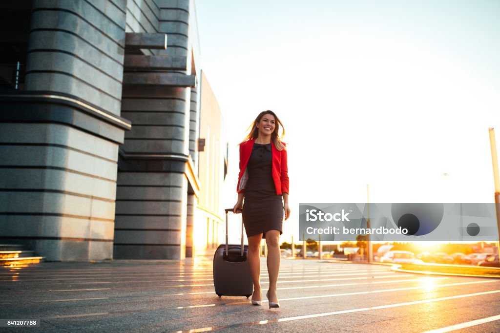 Pleased to have arrived Full length portrait of a well dressed business woman pulling a suitcase at the airport. Business Travel Stock Photo