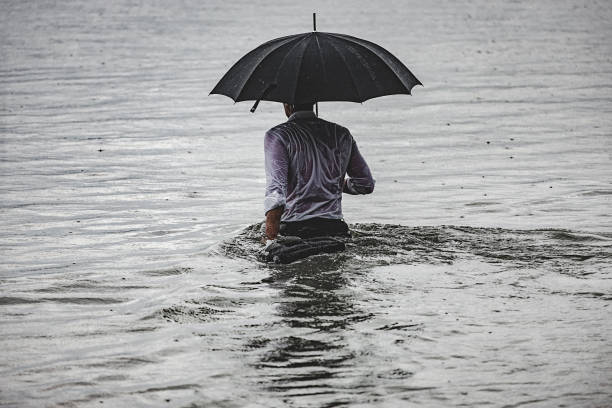 hombre en la lluvia - wading fotografías e imágenes de stock