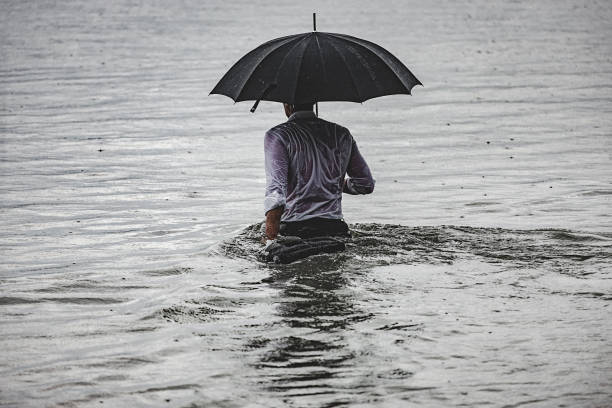 man on the rain - wading imagens e fotografias de stock