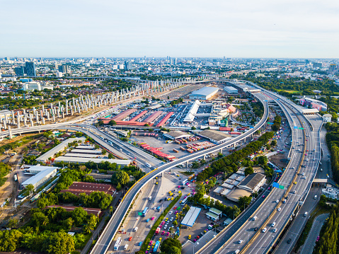 The present transportation of cars on highway and future transportation of sky train construction. The pillars are line in pattern far away out of Bangkok city.