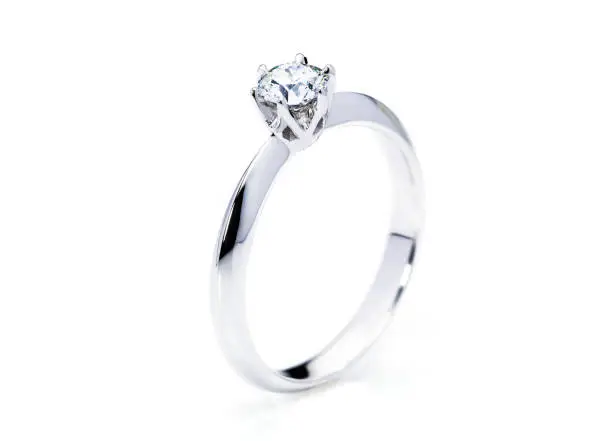 standing up beautiful diamond ring on white background, selective focus on diamond