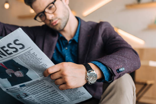 istock businessman reading newspaper in coffee shop 841211878