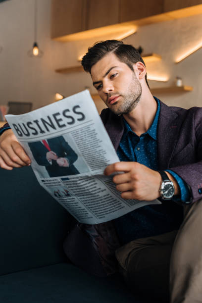 istock businessman reading newspaper in coffee shop 841214300