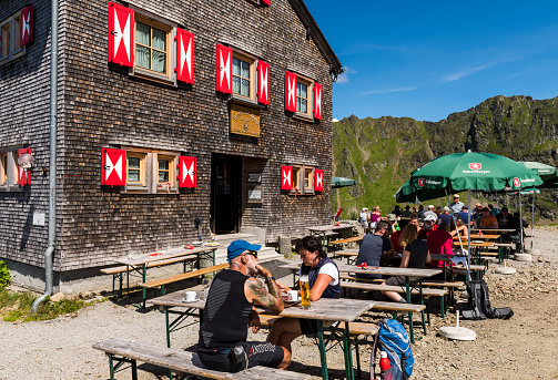 Tschaguns: People and hikers at the Wormser Hütte in the Montafon Alps on a summers day at the terrace of the restaurant, Austria.