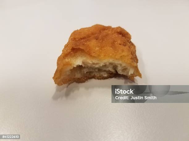 A Chicken Nugget With A Bite Taken Out Of It Stock Photo - Download Image Now - Biting, Food, Missing Bite