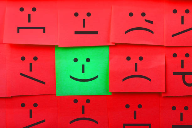 Emotions concept. Background of sticky notes. Green sticky note is among red sticky notes.