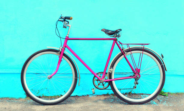 istock Retro old pink bicycle stands on a colorful blue background 841229230