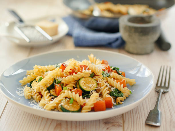 Italian food pasta with raw Spaghetti basil tomato garlic and olives in cast iron pot ready to cook on rustic wooden background