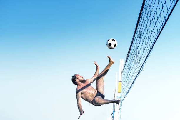 hombre brasileño pateando balón de fútbol sobre voleibol en río de janeiro - brazil beach copacabana beach recreational pursuit fotografías e imágenes de stock