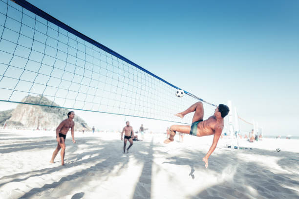 hombre brasileño pateando balón de fútbol sobre voleibol en río de janeiro - brazil beach copacabana beach recreational pursuit fotografías e imágenes de stock