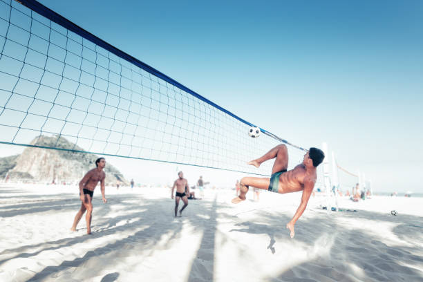 brazylijczyk kopiąc piłkę nożną nad siatką siatkową w rio - brazil beach copacabana beach recreational pursuit zdjęcia i obrazy z banku zdjęć