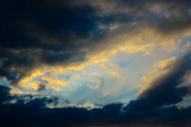 istock Between the dark clouds backlit by the sunset there is the full moon 841242284