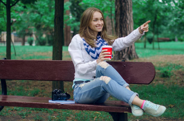 istock Beautiful young woman on a bench with coffee 841245310