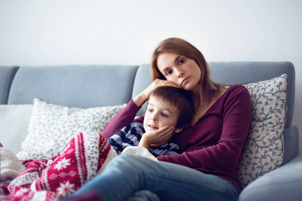 young mother, holding her little sick boy - offspring child lying on back parent imagens e fotografias de stock