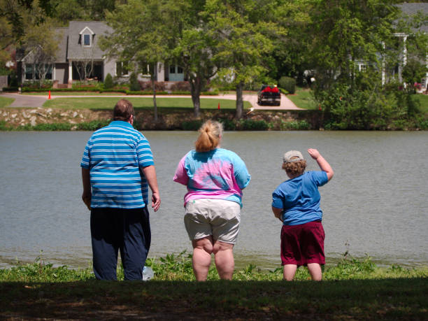 Family standing by a lake. stock photo