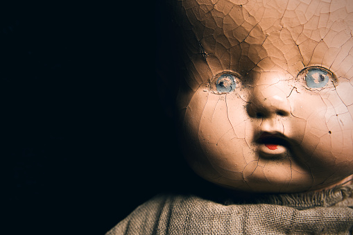 A close up of a creepy only antique baby doll face.