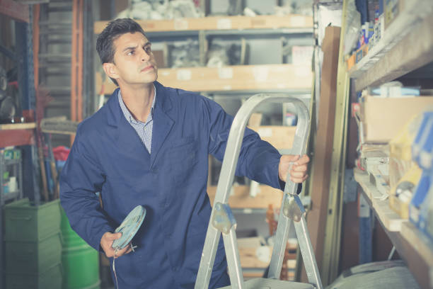 istock Man  is using ladder near shelving 841265316