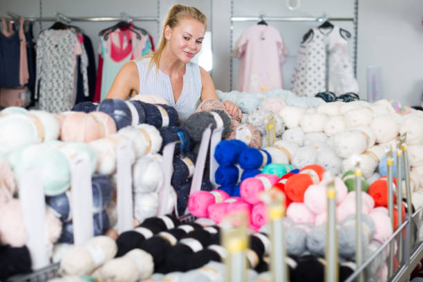 istock Happy woman choosing colored thread for knitting 841265740