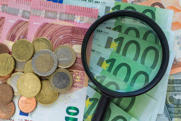 財務分析の概念としてのユーロ硬貨とユー��ロ紙幣の山の上の虫眼鏡 - magnification coin equipment european union currency ストックフォトと画像