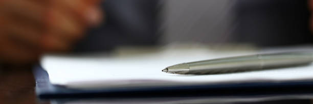 istock Silver pen lying on form clipped to pad closeup 841272020