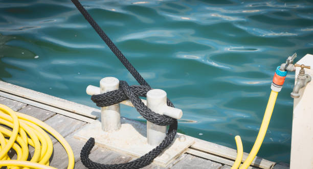 Attachment to boat on a wooden pontoon Boat tie on a pontoon at the water's edge bollard pier water lake stock pictures, royalty-free photos & images