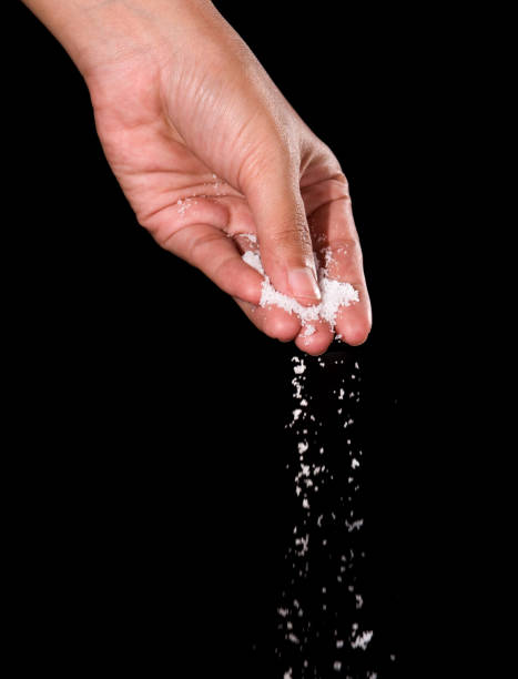 istock Hand sprinkling salt,salt over black background. 841279226