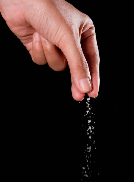 istock Hand sprinkling salt,salt over black background. 841282770