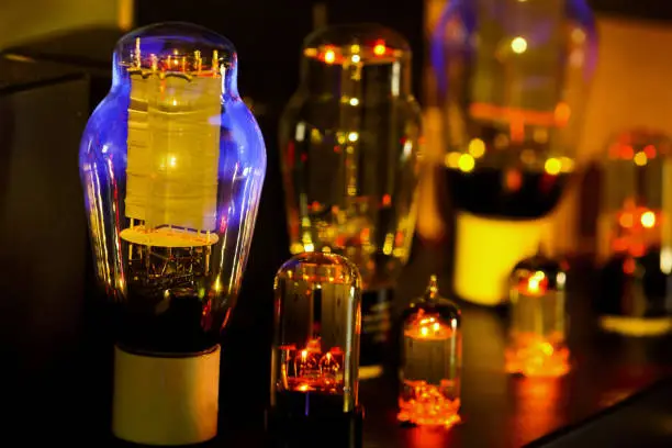 Night pictures of hi fi vacuum tubes amplifier Old-fashioned electronic device amplifier with glowing bulb diode lamp for sound reproduction . Focus only lamp