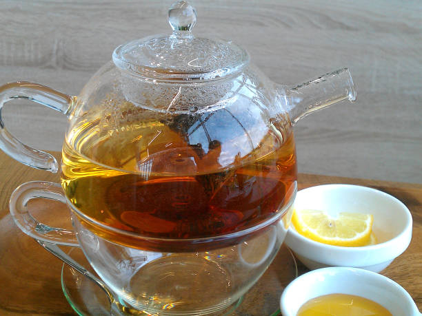 istock Green hot tea on a teapot on a wooden background. 841293056