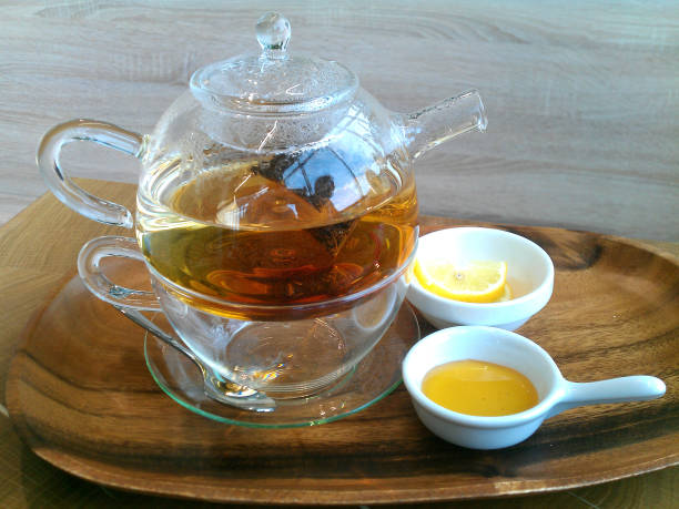 istock Green hot tea on a teapot on a wooden background. 841293338