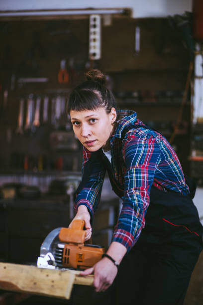 istock Attractive Young Brunette Woman Efficient With Hand Saw 841297528