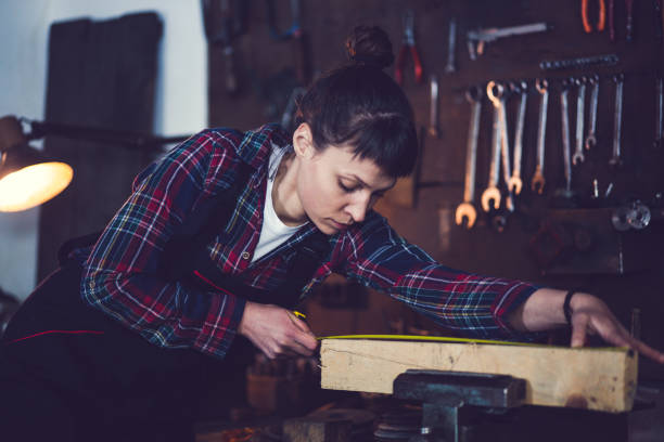 istock Young Woman Measuring Wooden Plank 841297646