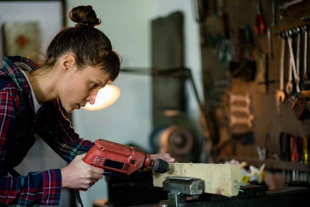 istock Female Carpenter Drilling Wooden Plank 841297664