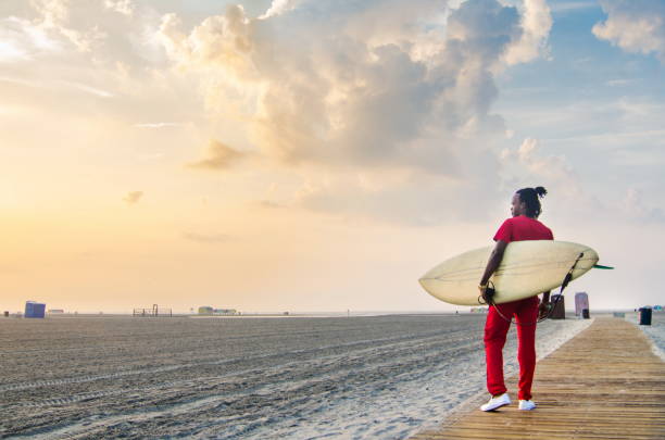 istock Young man walking towards seaside with surfboard 841303762