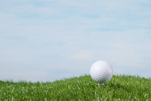 istock golf ball stands on a tee against the sky 841303942